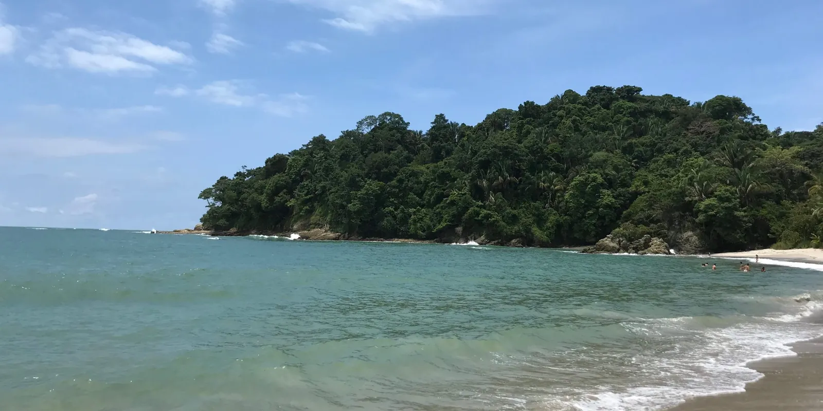 A beach in Manuel Antonio National Park, with a forested headland