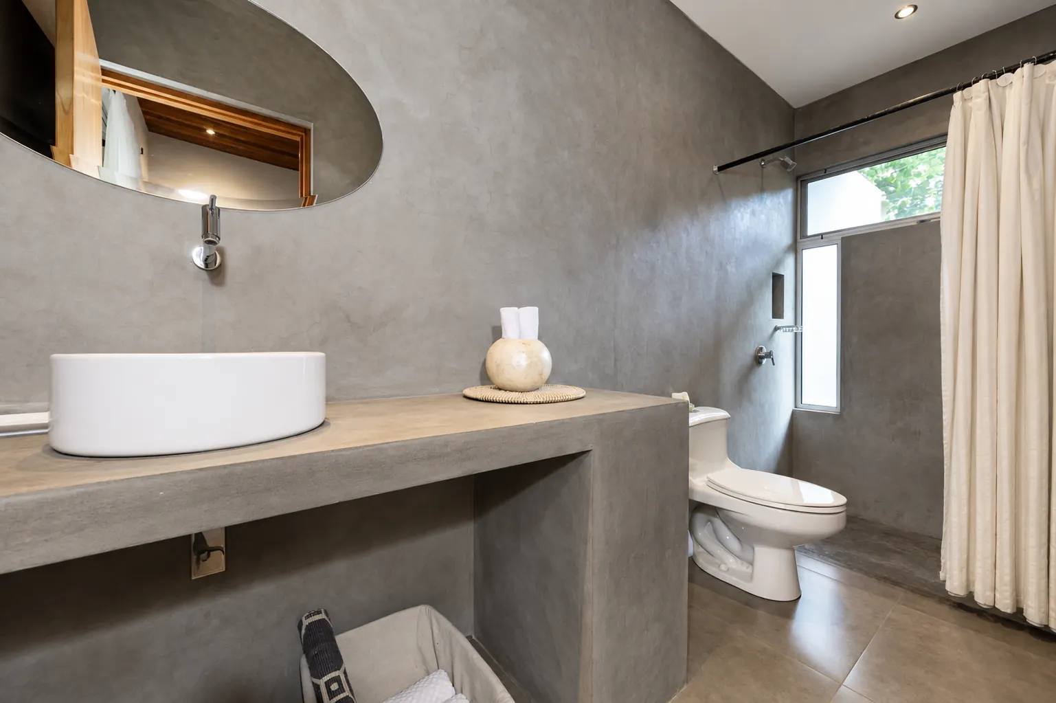 Bathroom in polished concrete with a vessel sink on a timber counter