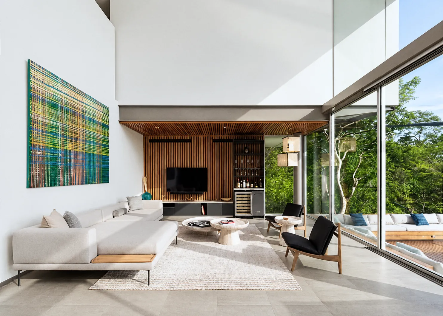 Double-height living room with a timber wall, open to the garden through full-height glass